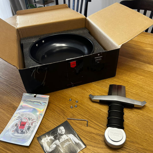 Unboxed EGGSCALIBUR PAN kitchen appliance with parts and accessories on a wooden table