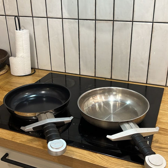 Eggscalibur Pan Two frying pans on a stove with a tiled wall in the background