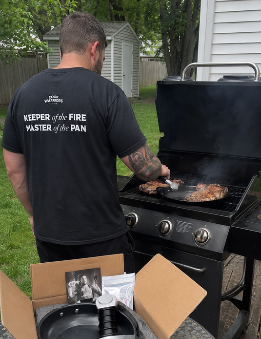 Person grilling on a barbecue with a portable grill set in front using EGGSCALIBUR SWORD FRYING PAN STAINLESS STEEL CAST IRON CUSTOMER BUY COOKWARRIORS AMAZON
